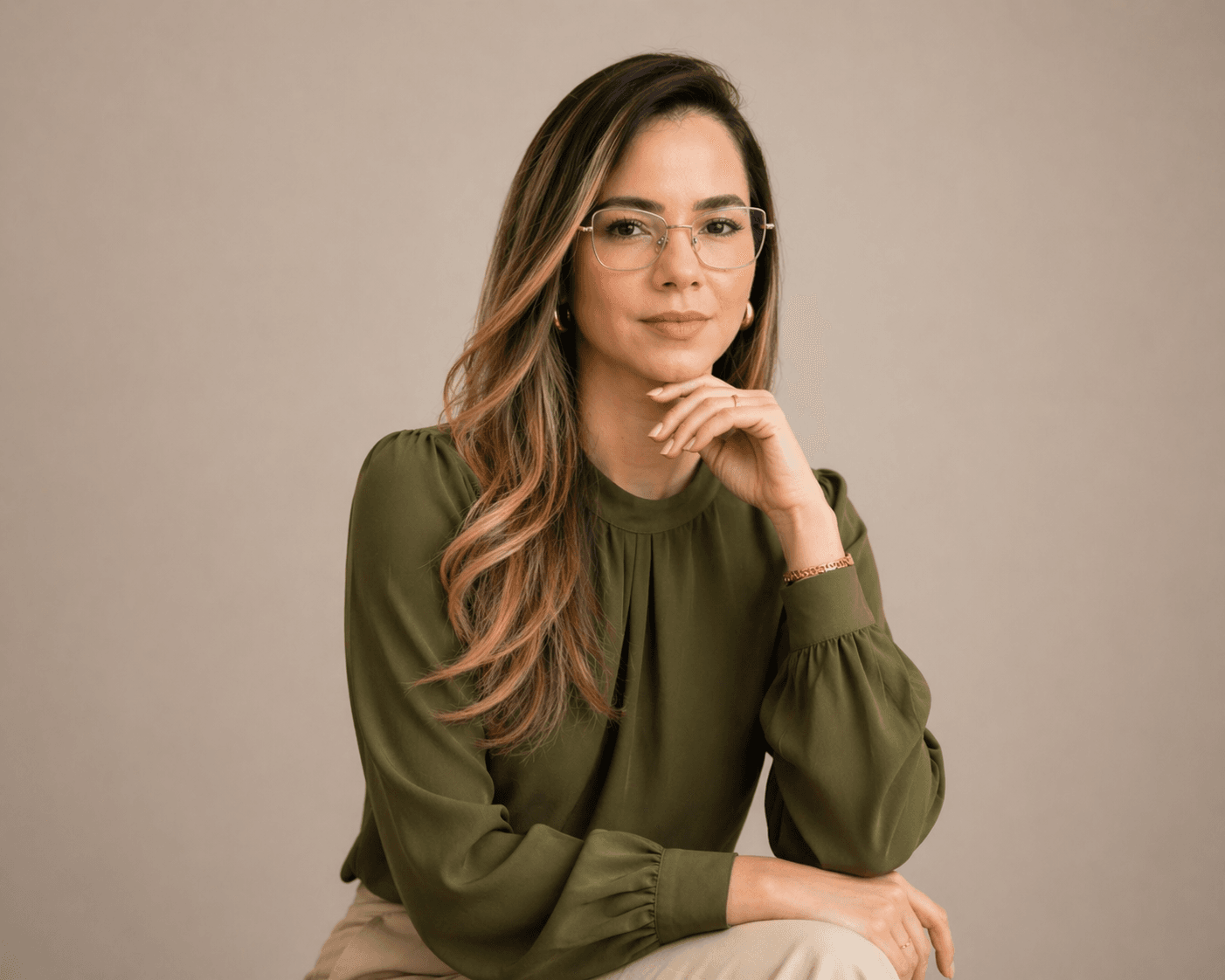 Tamires Câmara sentada, olhando para a câmera, em ambiente claro e profissional